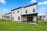 back of 2-story home with covered patio and landscaping