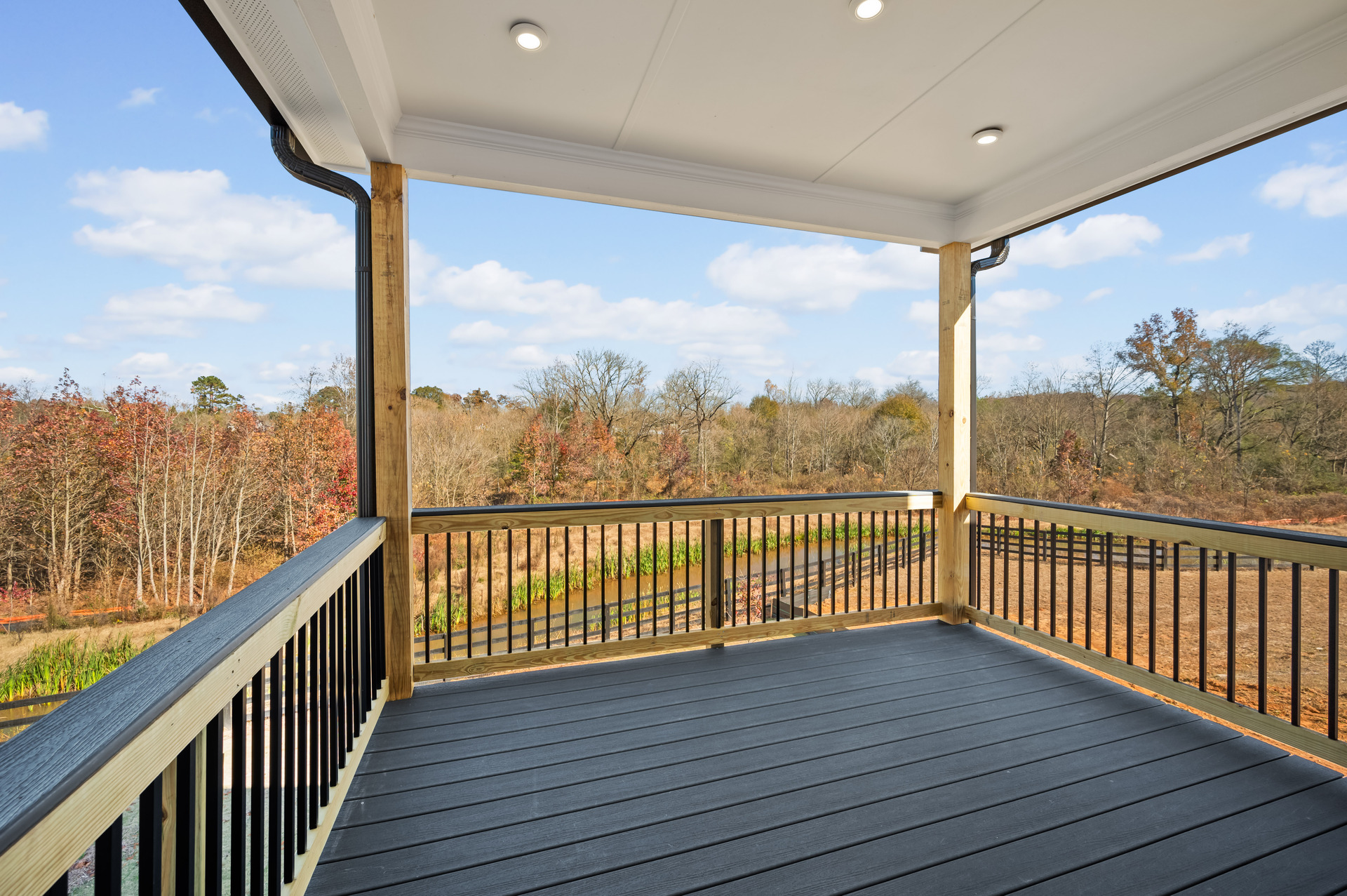covered deck and treelined view of backyard