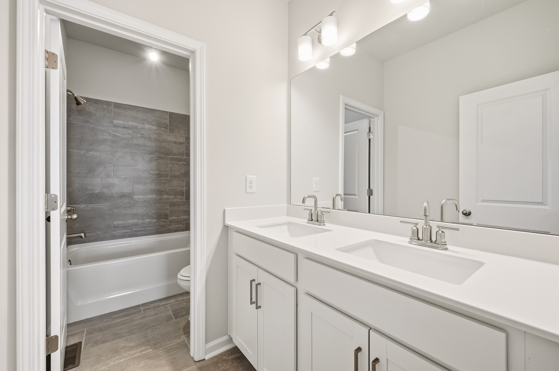 secondary bathroom with dual vanity and water closet