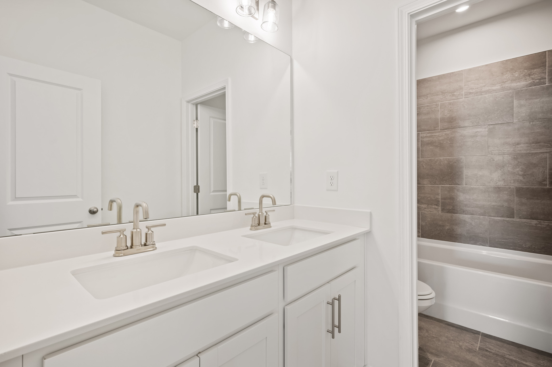 secondary bathroom with dual vanity and water closet