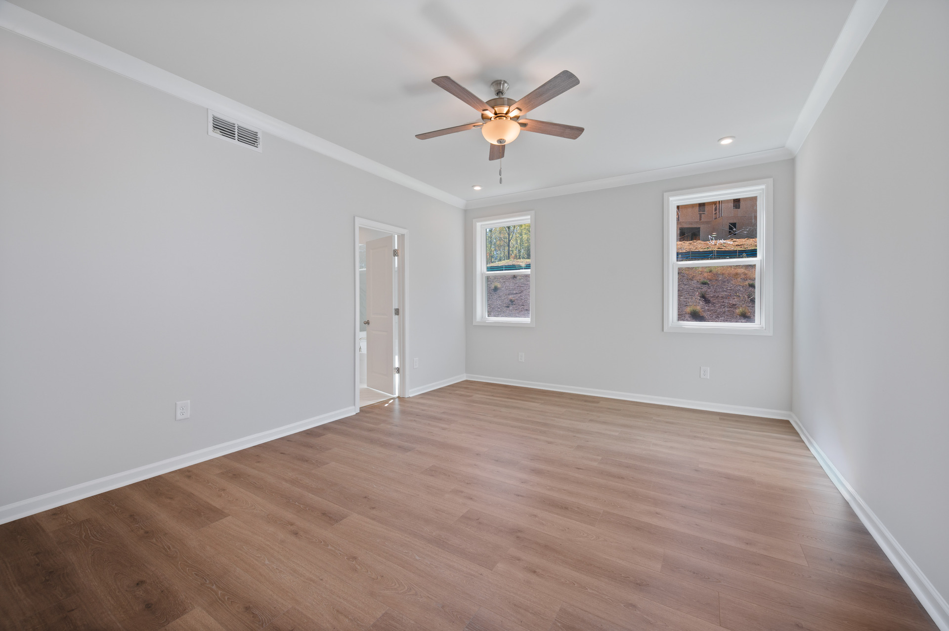 primary bedroom with windows and ceiling fan