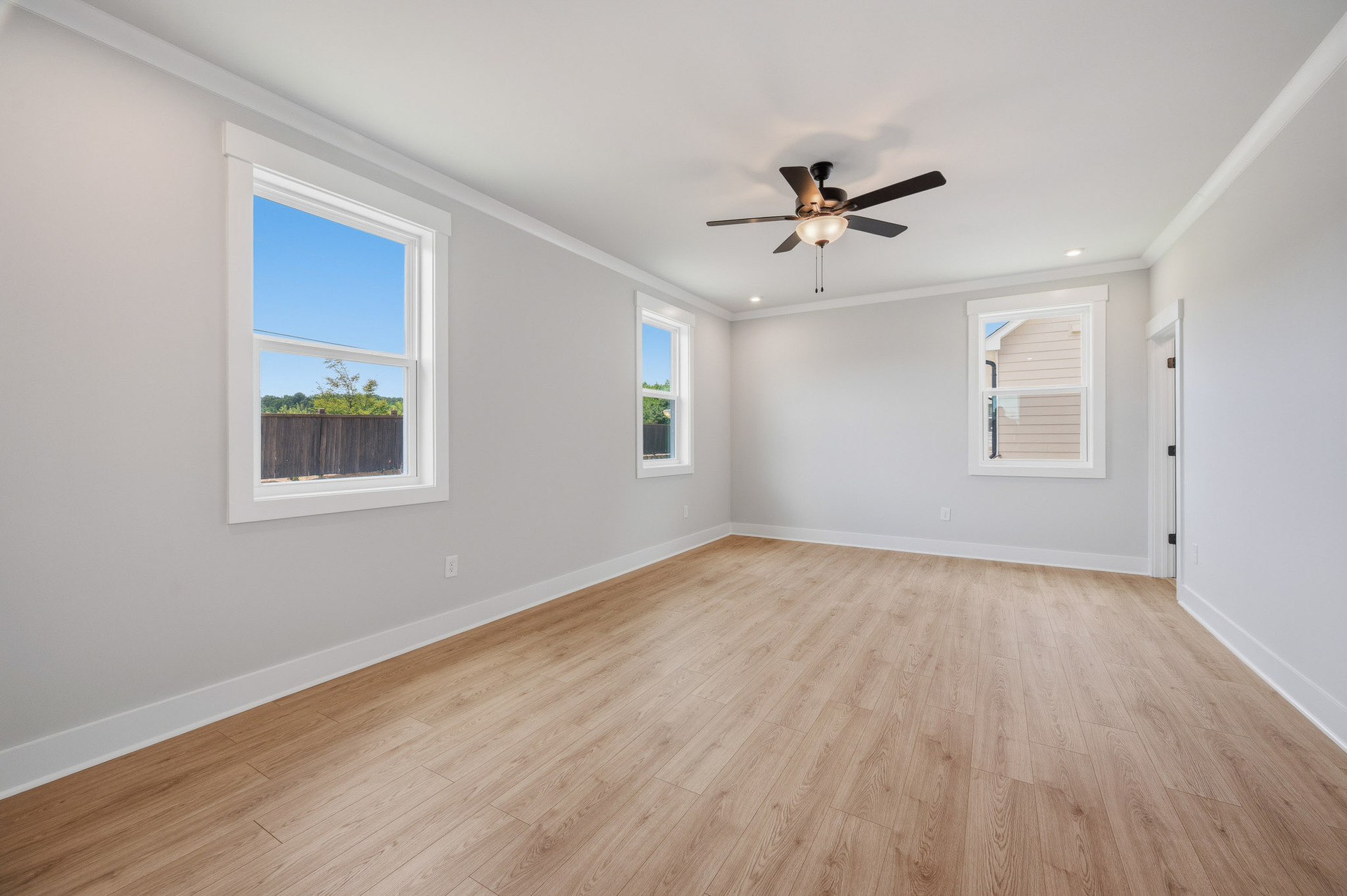 primary bedroom with windows and hard surface floors