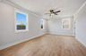 primary bedroom with windows and hard surface floors