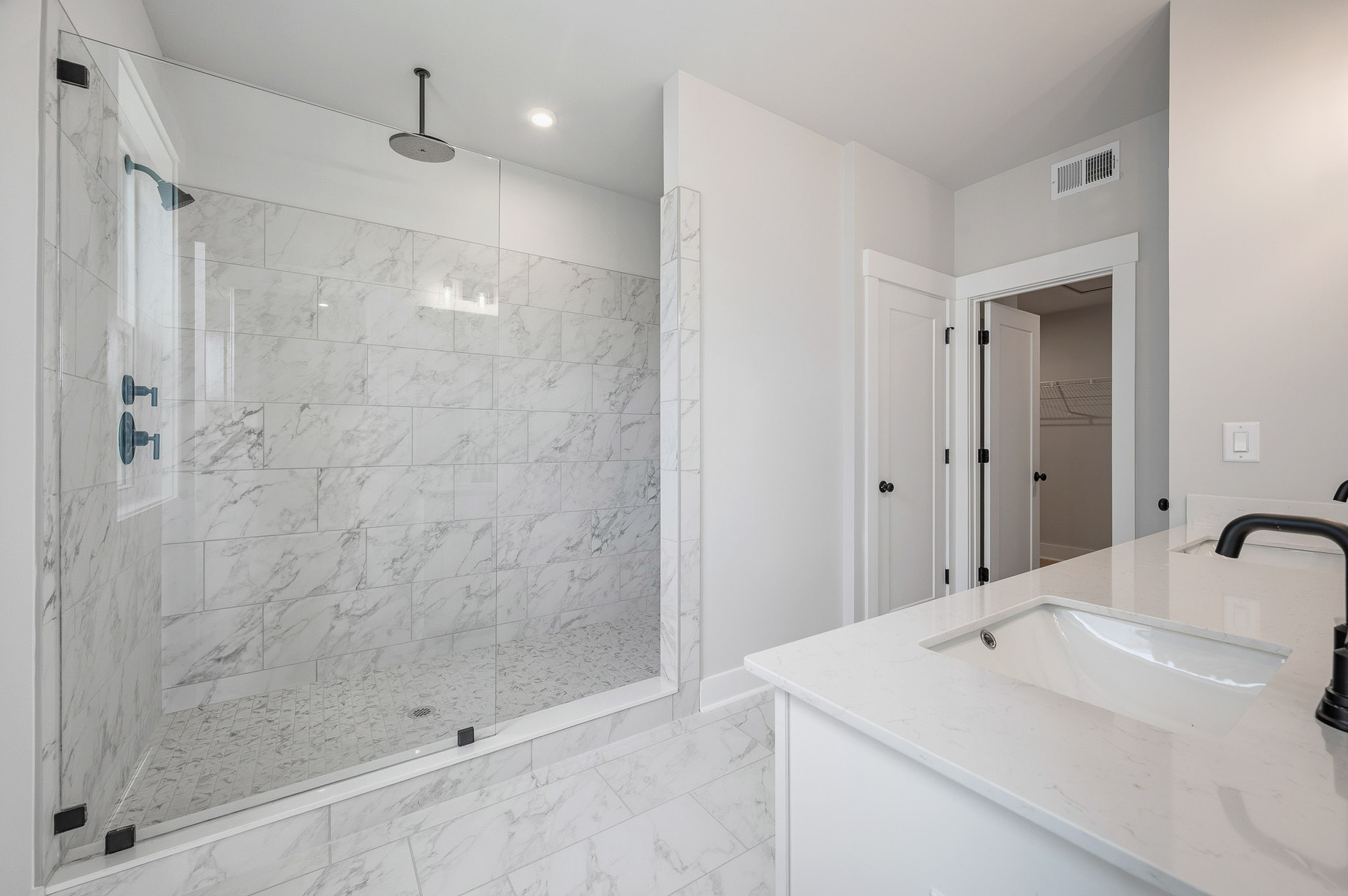 primary bathroom with large walk-in shower and tile flooring
