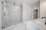 primary bathroom with large walk-in shower and tile flooring
