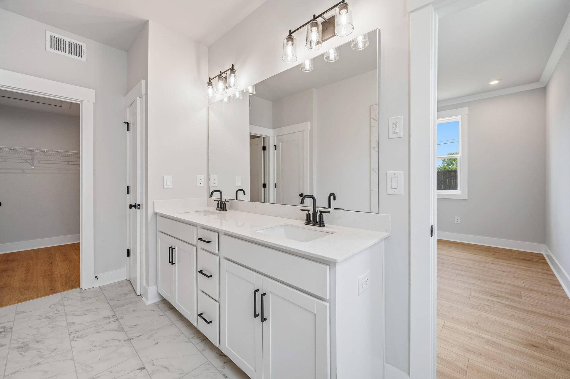 primary bathroom with white cabinets and tile flooring