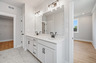 primary bathroom with white cabinets and tile flooring 