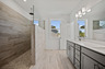 primary bathroom with a large walk-in shower and dual vanity