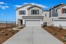 two-story exterior with a white windowless garage and a beige brick trim