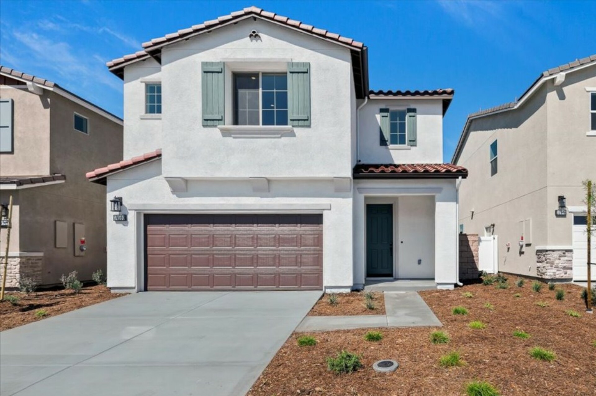 two-story exterior with a brown windowless garage and three windows