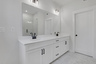 primary bathroom with white cabinets and tile flooring