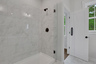primary bathroom with walk-in shower and tile flooring
