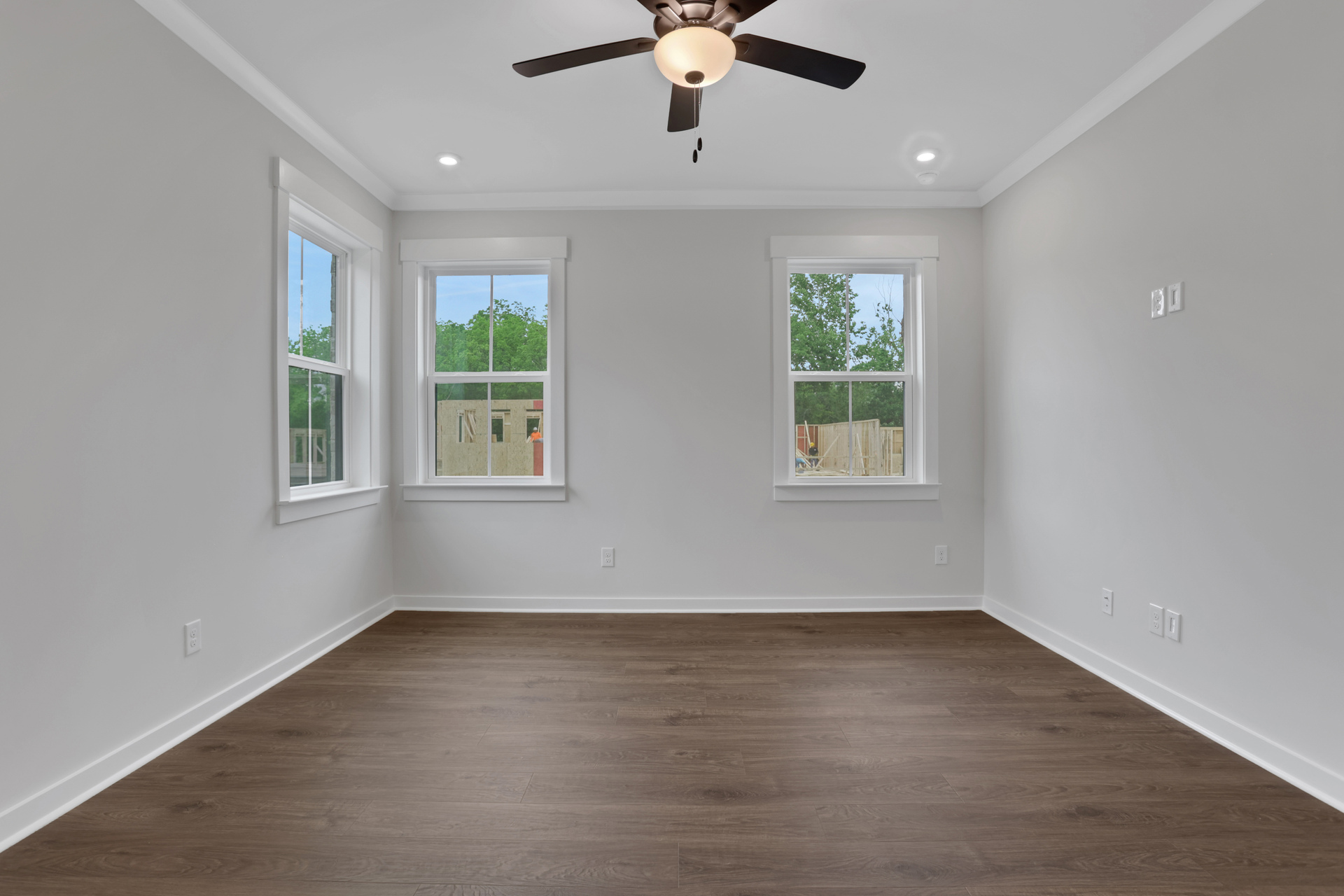 primary bedroom with windows and hard surface floors