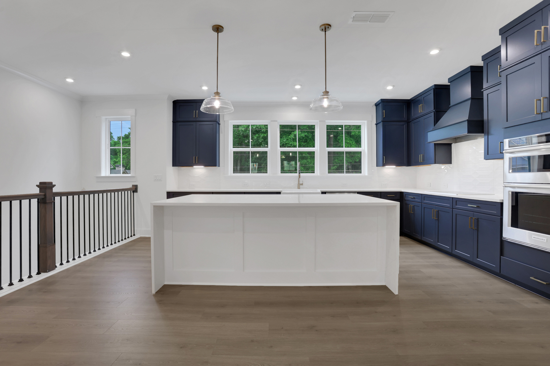 kitchen with dark blue cabinets and white quartz counters