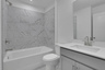 secondary bathroom with gray cabinets and tile flooring