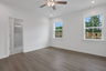 primary bedroom with windows and hard surface floors