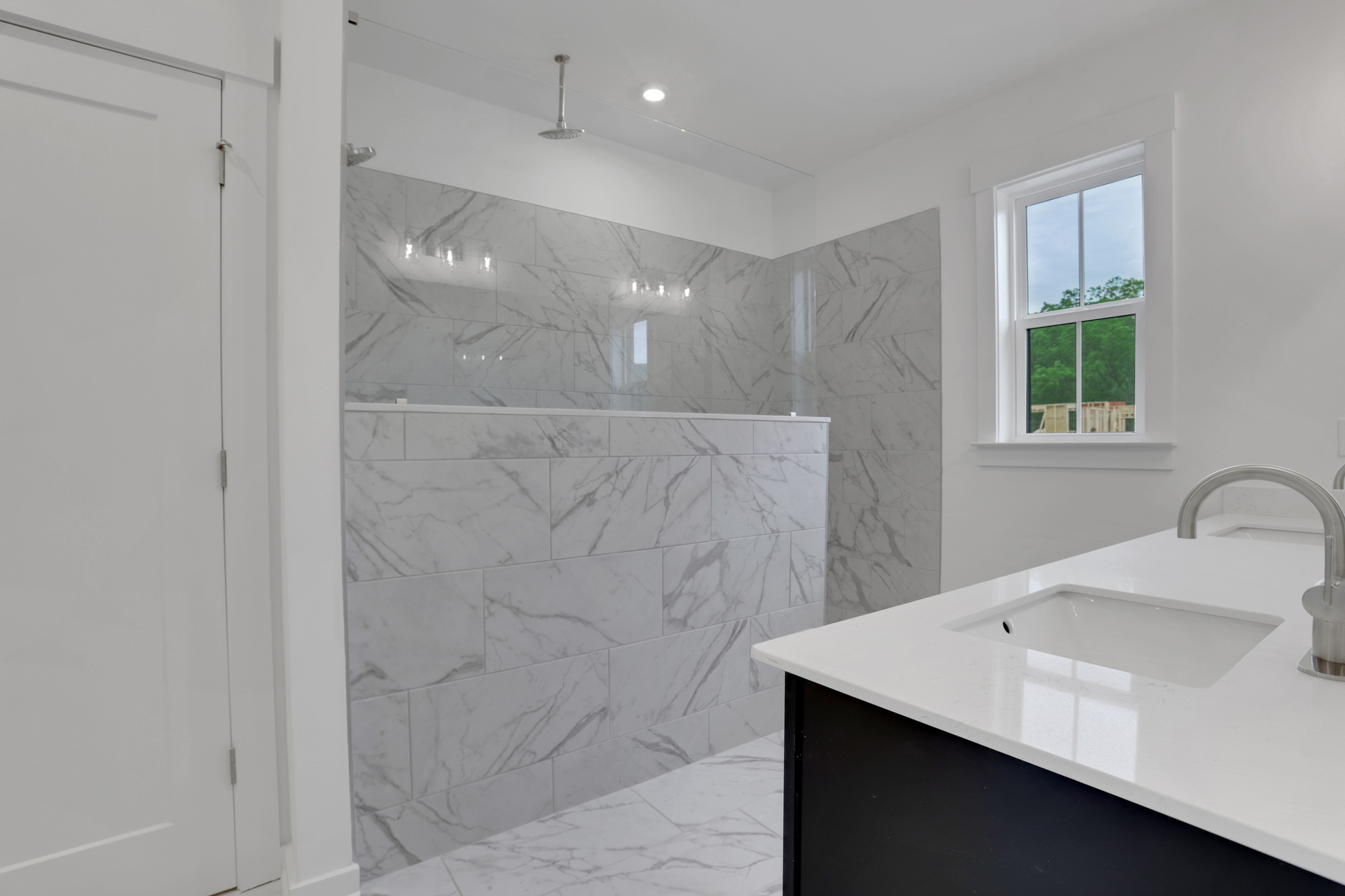 primary bathroom with oversized walk-in shower and tile flooring