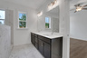 primary bathroom with dark cabinets and tile flooring