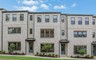 front of 3-story townhome with light brick and wood accents