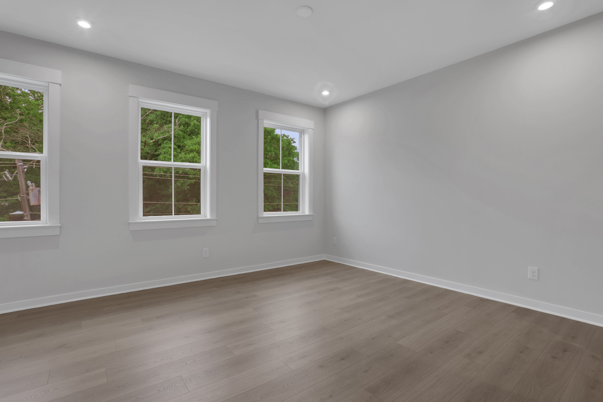 primary bedroom with windows and hard surface floors