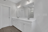 primary bathroom with white cabinets and tile flooring
