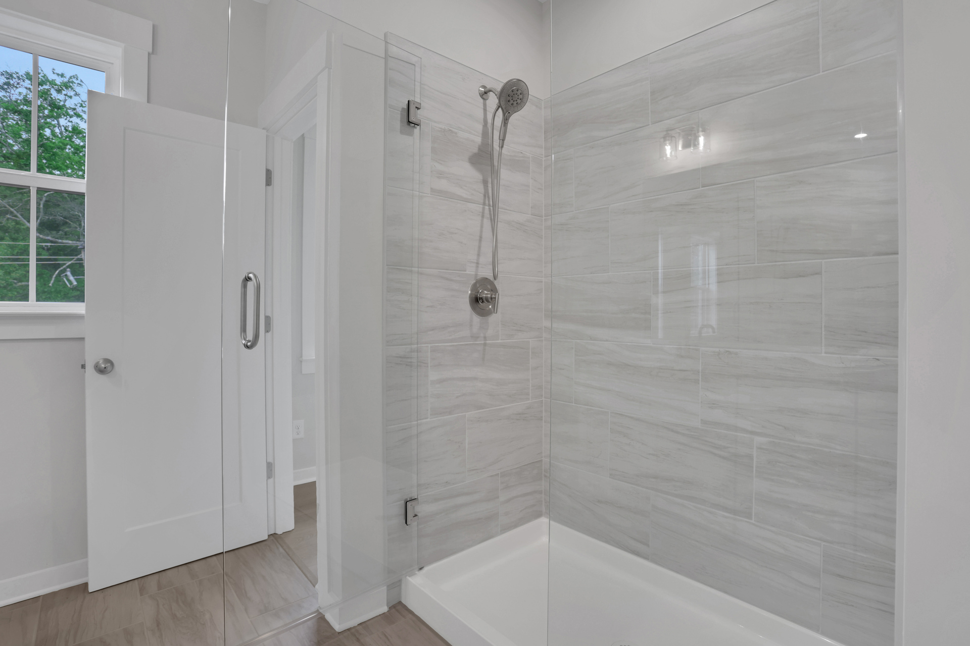 primary bathroom with walk-in shower and tile flooring