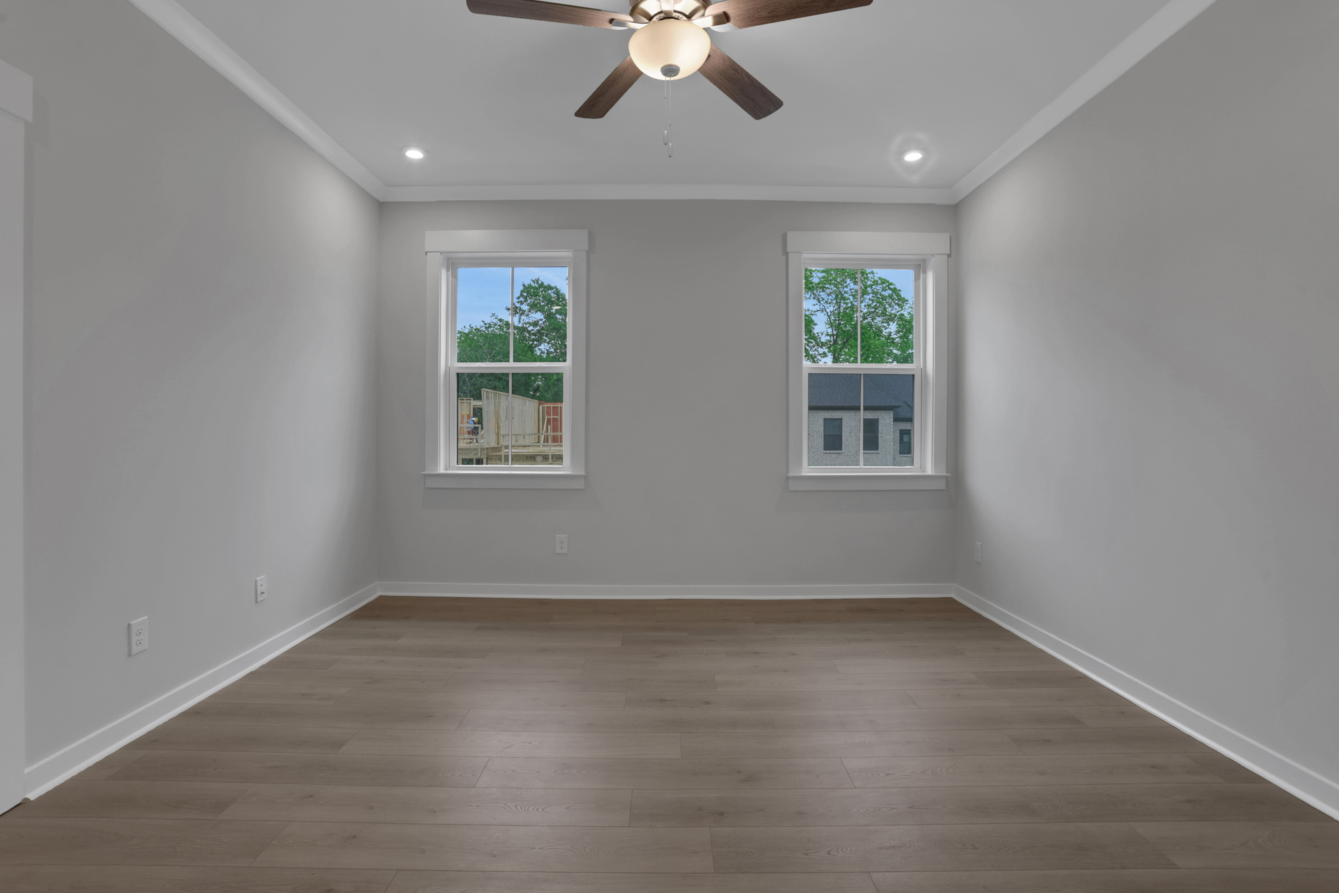 primary bedroom with windows and hard surface floors