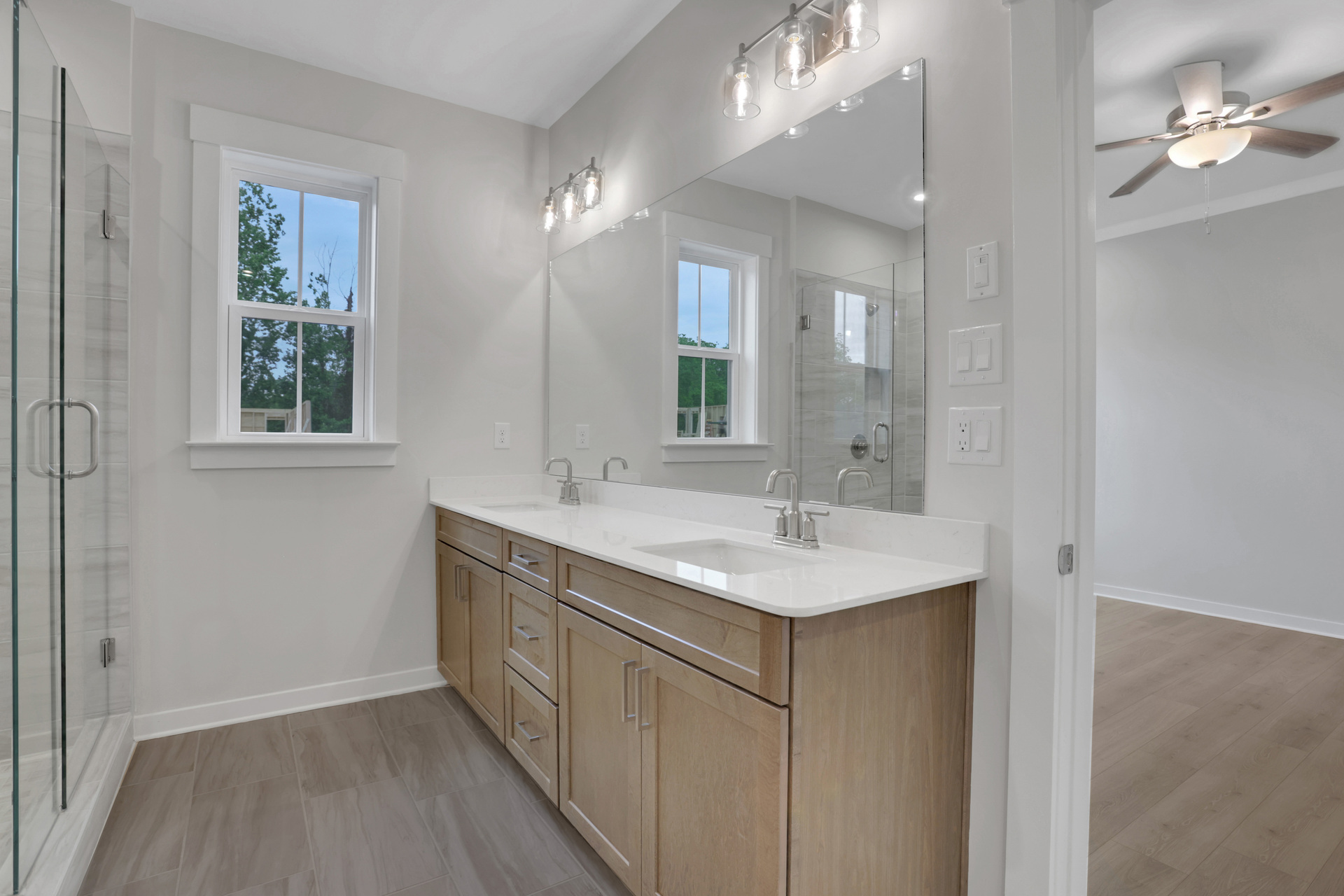primary bathroom with wood-finish cabinets and tile flooring
