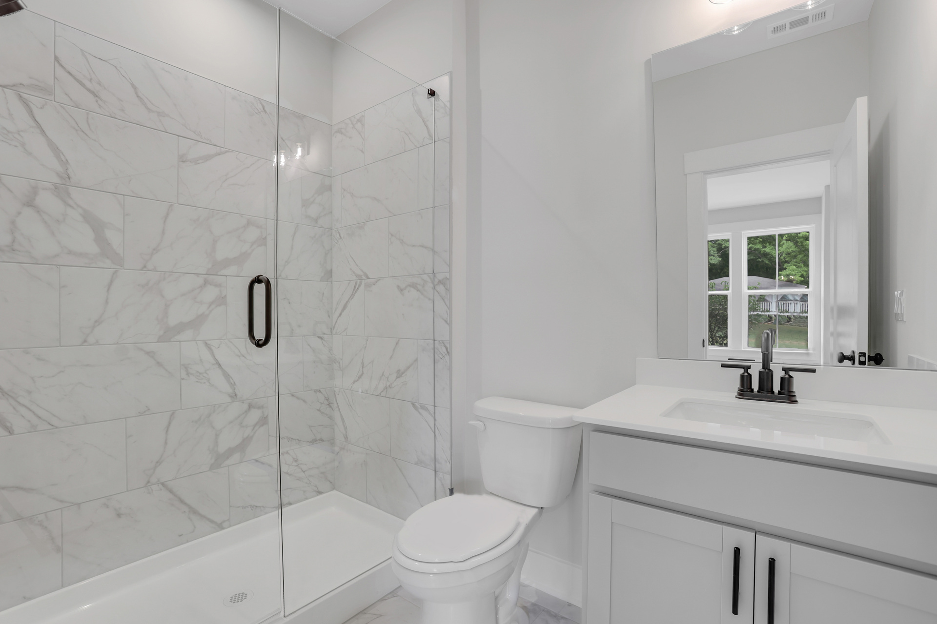 secondary bathroom with gray cabinets and tile flooring