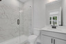secondary bathroom with gray cabinets and tile flooring