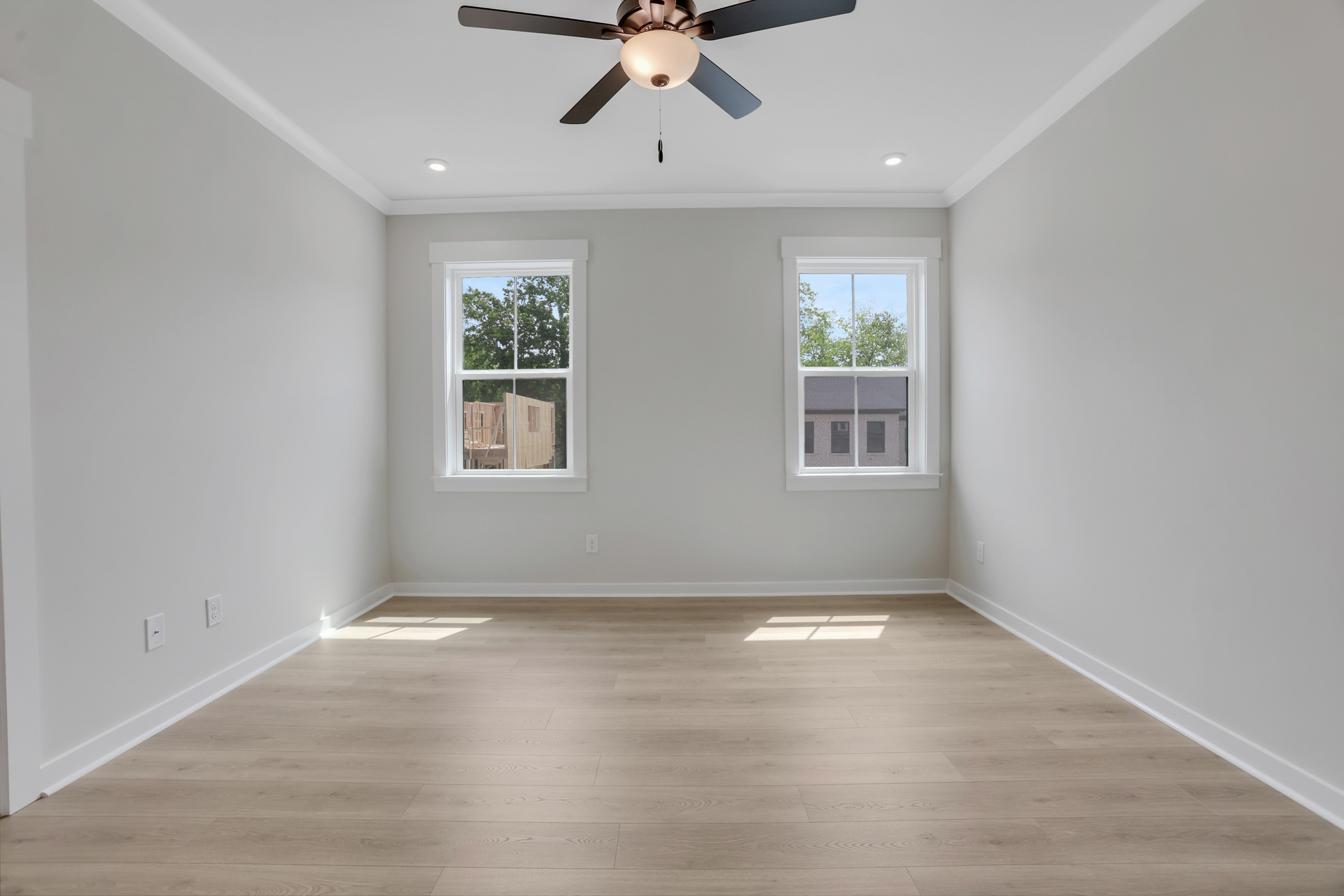 primary bedroom with windows and hard surface floors