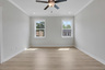 primary bedroom with windows and hard surface floors