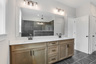 primary bathroom with wood-finish cabinets and tile flooring 