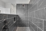 primary bath with large walk-in shower and black tile