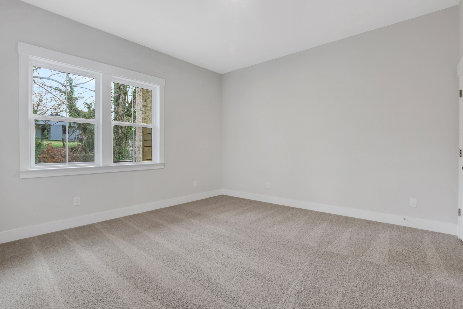 secondary bedroom with carpet and windows