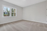 secondary bedroom with carpet and windows