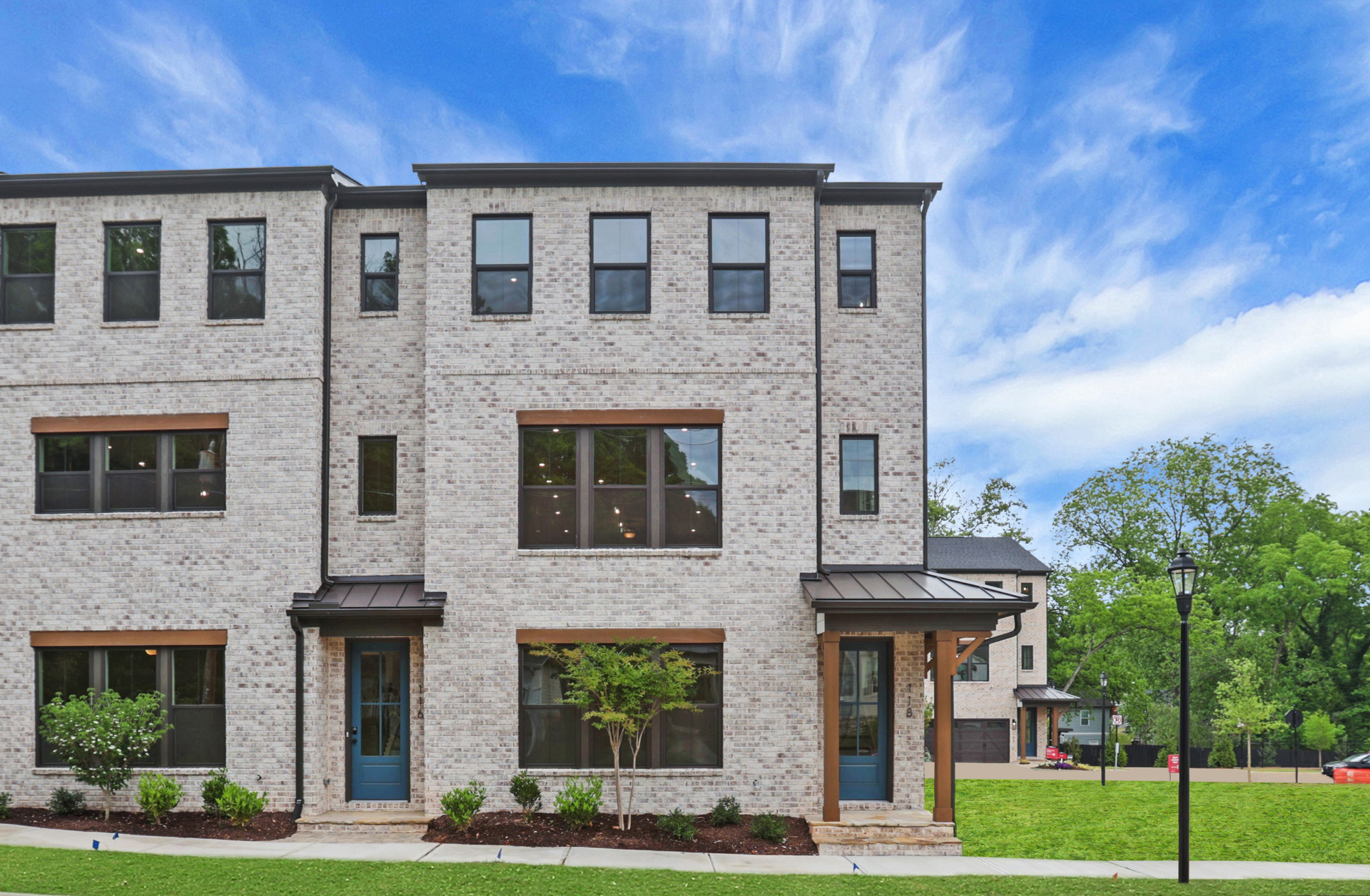 front of 3-story townhome with light brick and wood accents