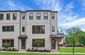 front of 3-story townhome with light brick and wood accents