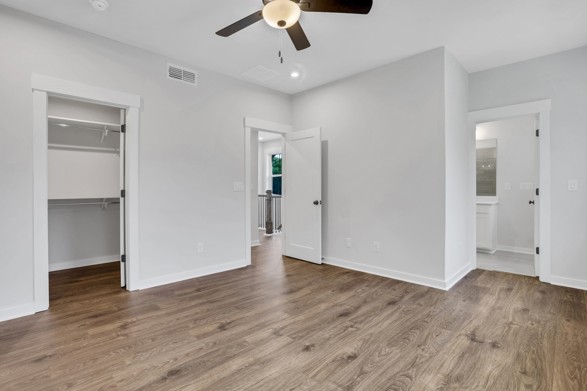 primary bedroom with windows and hard surface floors