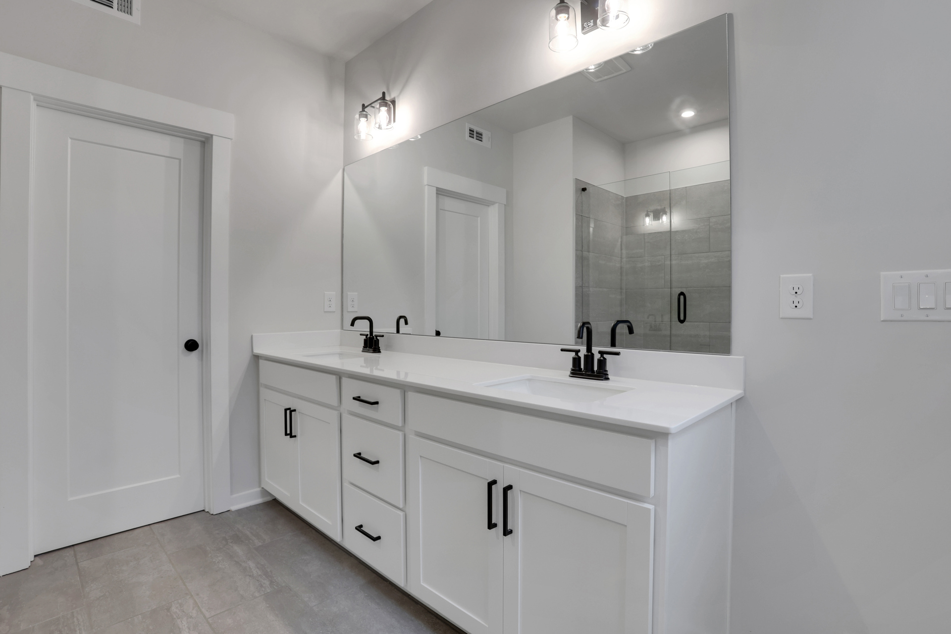 primary bathroom with white cabinets and tile flooring