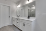primary bathroom with white cabinets and tile flooring 