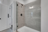 primary bathroom with walk-in shower and tile flooring 