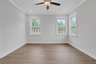 primary bedroom with windows and hard surface floors