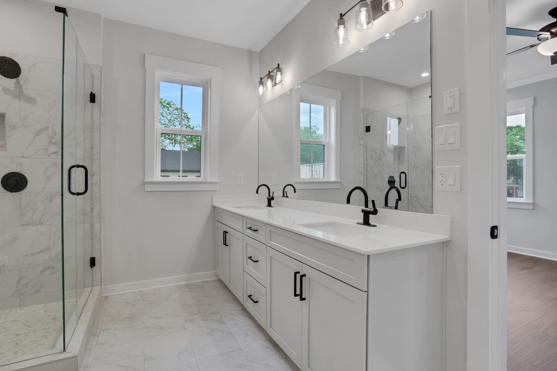 primary bathroom with white cabinets and tile flooring