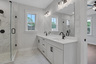 primary bathroom with white cabinets and tile flooring 