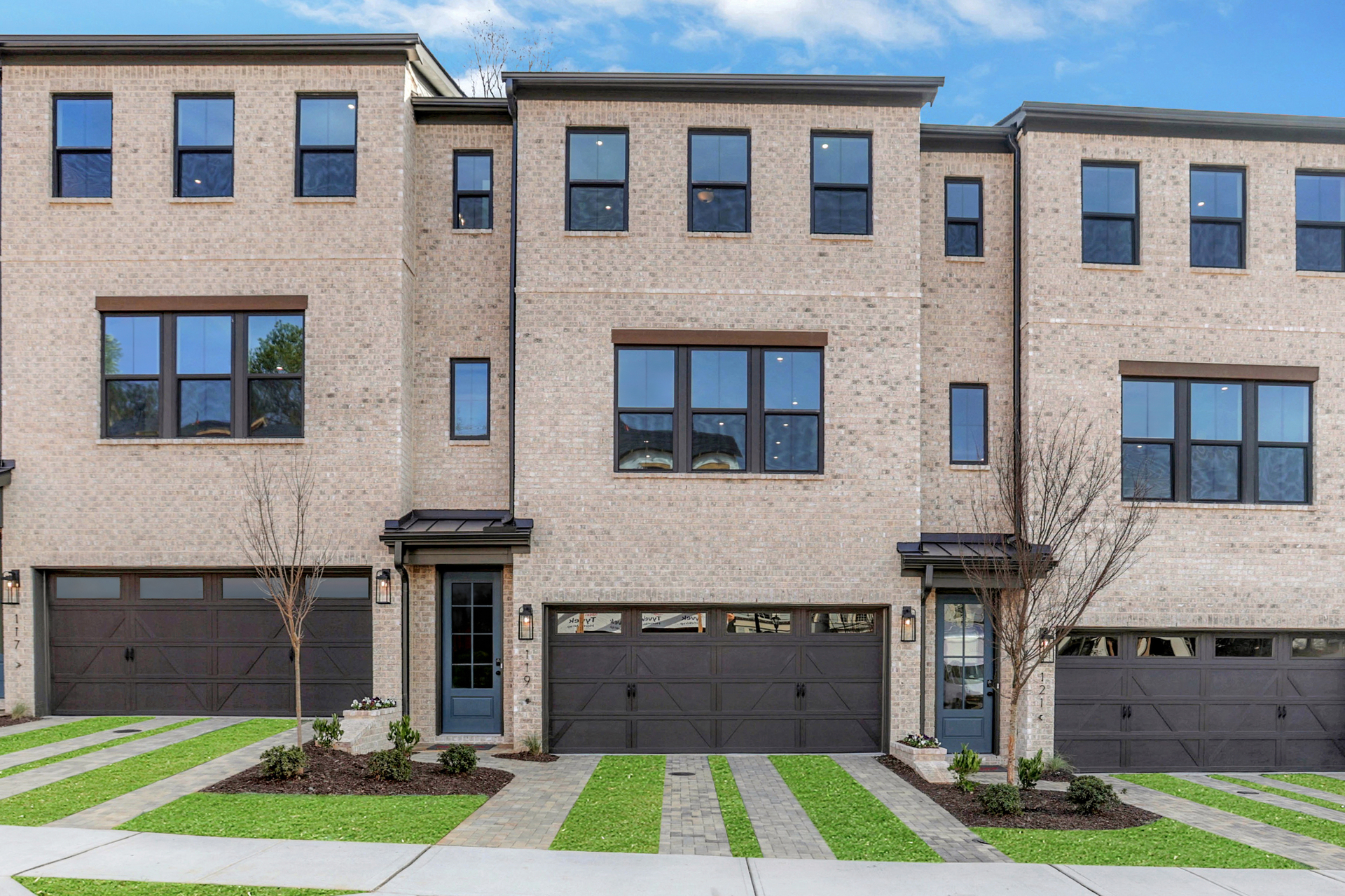 front of 3-story townhome with light brick and wood accents
