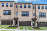 front of 3-story townhome with light brick and wood accents
