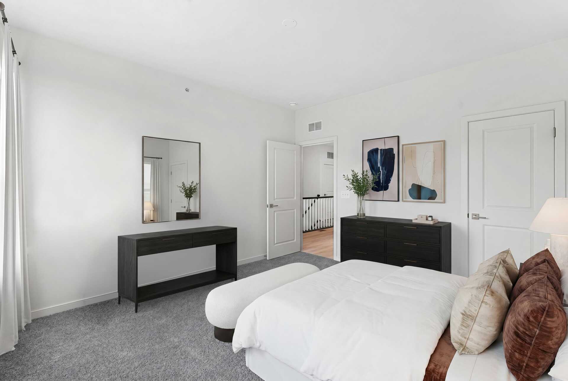 large bed with dresser and paintings