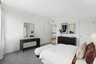 large bed with dresser and paintings