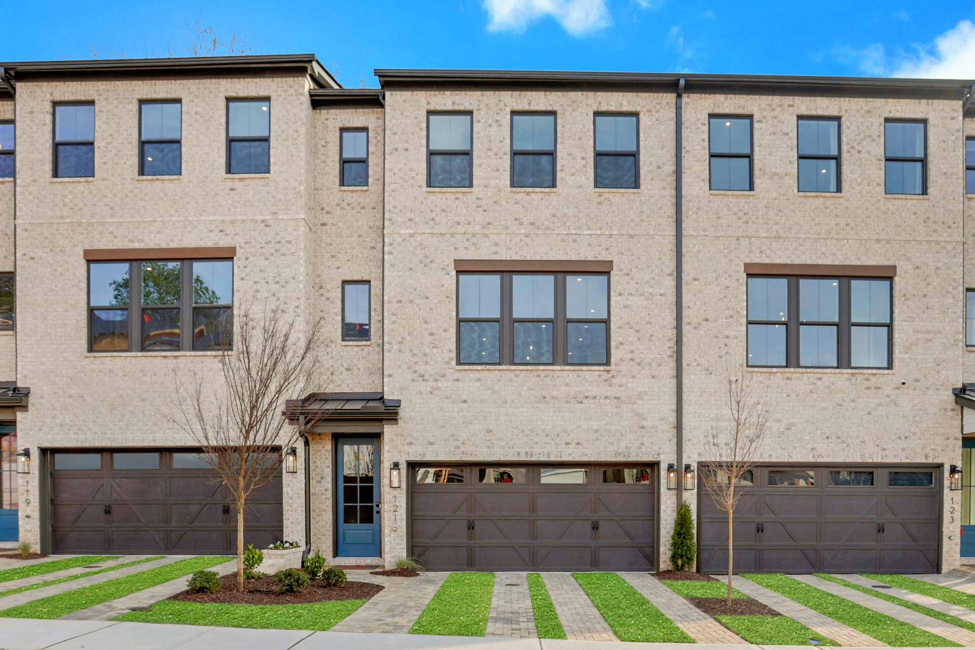 front of 3-story townhome with light brick and wood accents